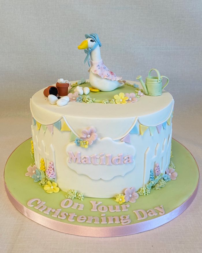 Single tier christening cake with a Jemima Puddle-Duck topper, bunting and spring flowers