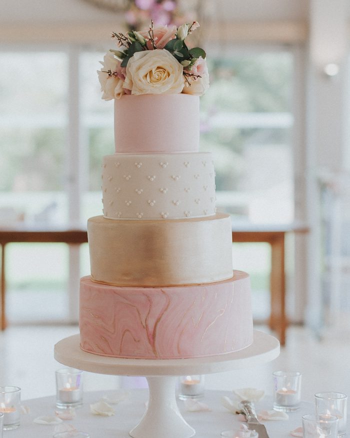 Four-tier pink and gold marble wedding cake with fresh roses by Catherine Scott
